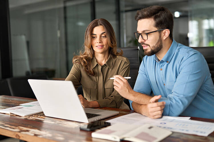 Asian woman looking at laptop in office setting
